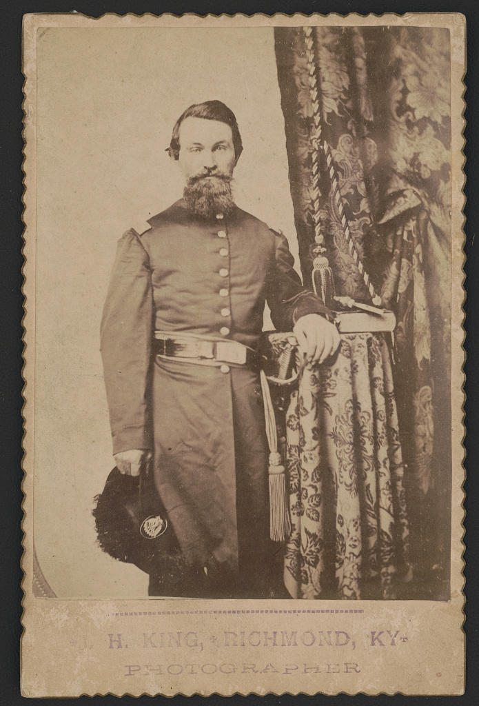 [Captain John Wilson of Co. C, 8th Kentucky Infantry Regiment (Union), in uniform with sword; revolver and book rest on table], 1862 (Library of Congress)