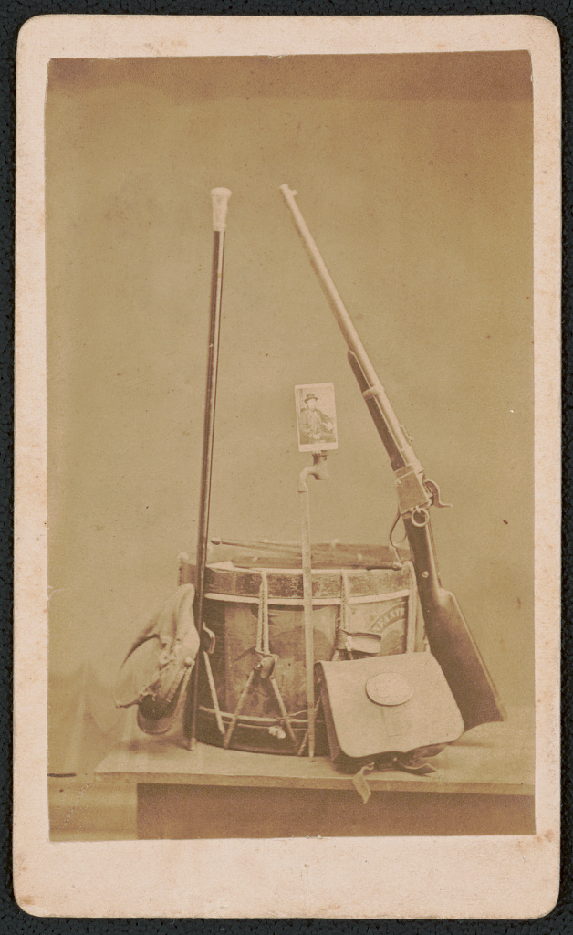 [Carte de visite portrait of John L. Burns affixed to bayonet in still life with cane, cap, drum, cartridge box, and rifle], 1872 (Library of Congress)