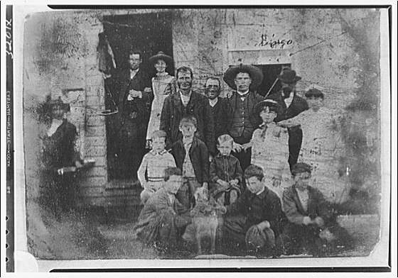 Copy photograph of family in front of building, 1920 (Library of Congress)