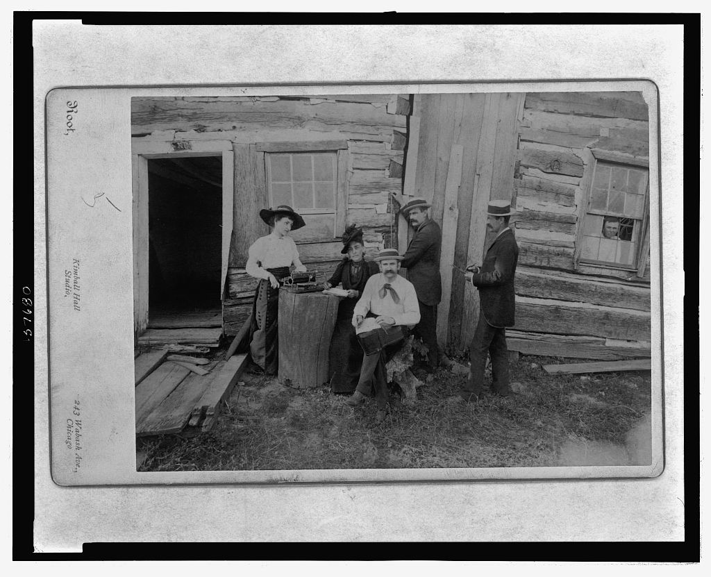 Front view of a portion of the Lincoln cabin with a group composed of Mrs. Norah Gridley, Miss Mary Coleman, the typewriter, the brothers Megar, architects, and Mr. Stille, and showing young Hall a gr, 1891 (Library of Congress)