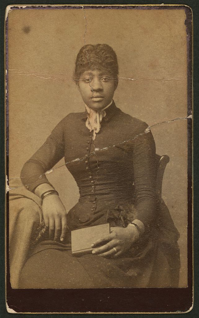 [Three-quarter-length portrait of an African-American woman seated, facing front, holding book], 1870 (Library of Congress)